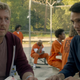 William Zabka's Johnny Lawrence and Ralph Macchio's Daniel LaRusso are wearing visitor badges while sitting in the yard of a prison in Cobra Kai.